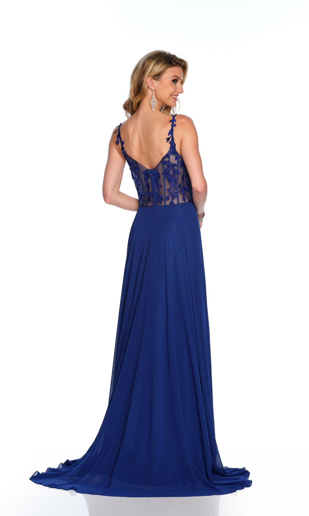 A woman wearing the Long Formal Dress 11582 by Dave and Johnny, a floor-length royal blue A-line gown with thin straps and a sheer lace embroidered bodice, photographed from the back.